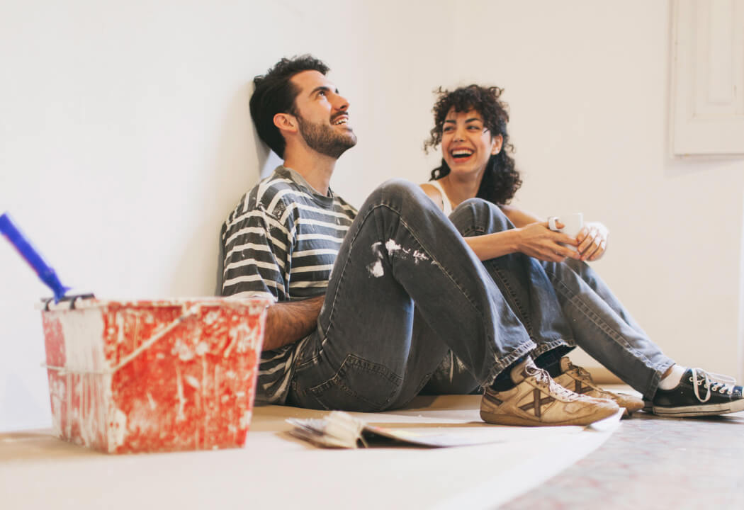 Young couple painting a white room